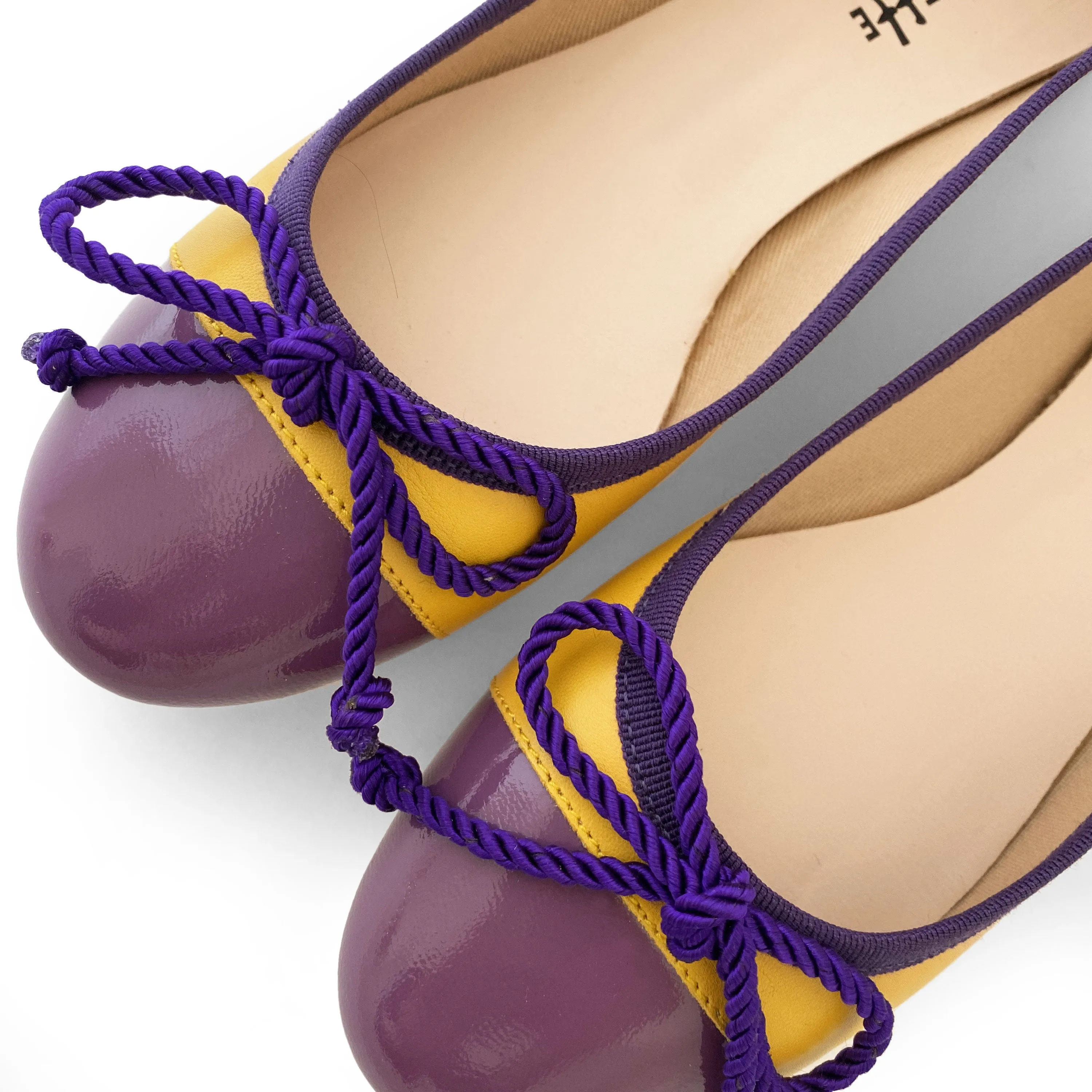 Yellow leather ballet flats with purple toe and bow